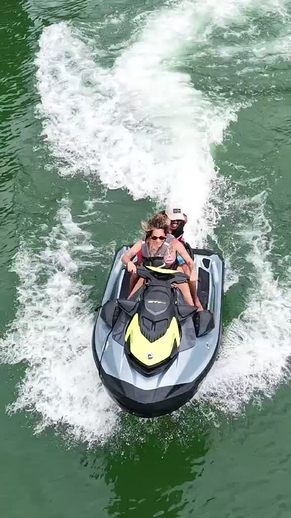 Pareja sonriendo en el jet ski, video con dron